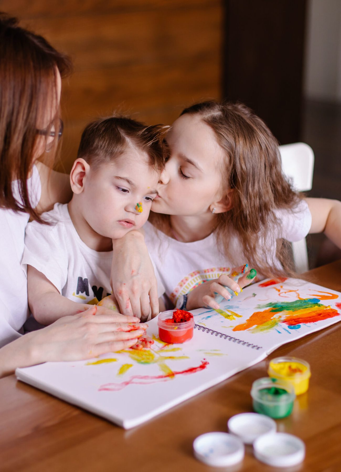 Mother draws with children at home. Development of a child with cerebral palsy. Friendship caring kindness and love. Rehabilitation by creativity. Family with a disabled child. Togetherness lifestyle